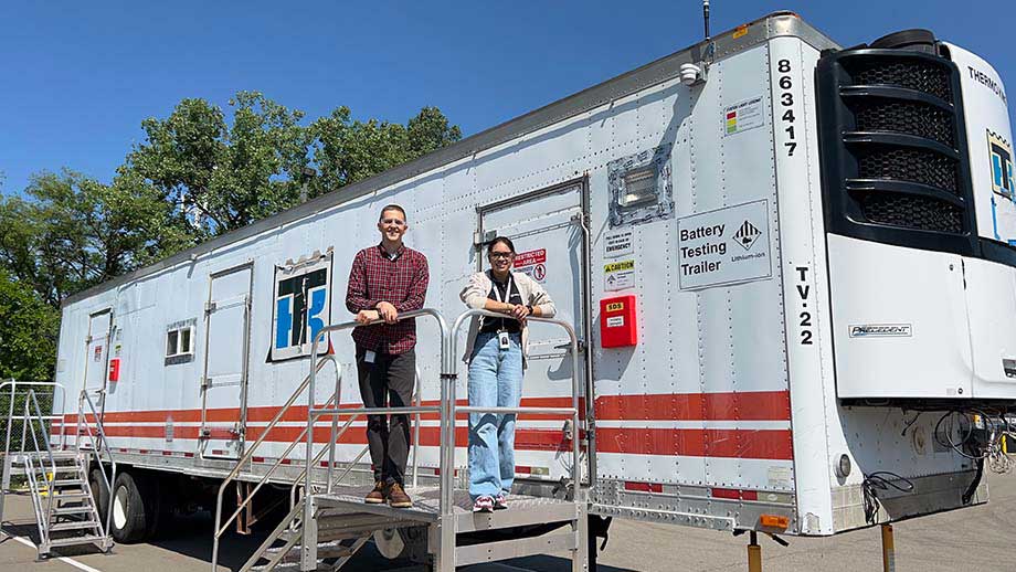 Employees outside of the battery testing trailer
