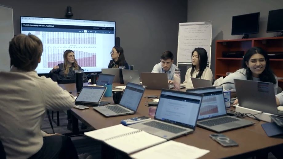 graduate trainees working on laptops in conference room
